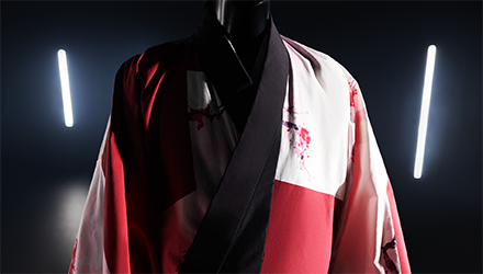close-up of the top half of a white and red kimono with cherry blossom designs and a black border.