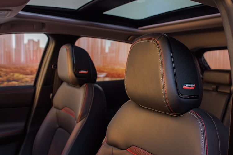 The black leather driver and passenger seat headrests featuring red stitching in the 2025 Nissan Kicks.